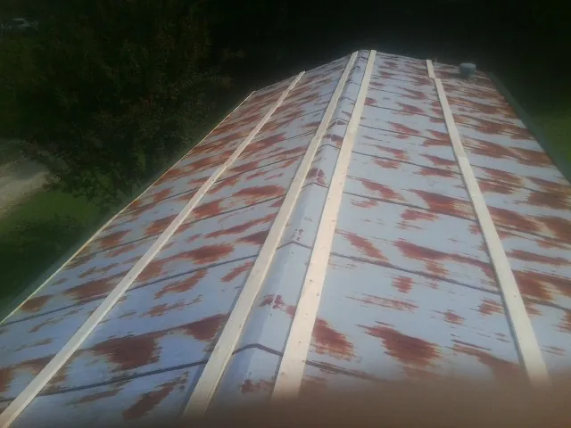 Rusted metal roof panels with new wood purlins before replacement — Storm Damage Roof Repair in High Ridge by Roofing Brothers
