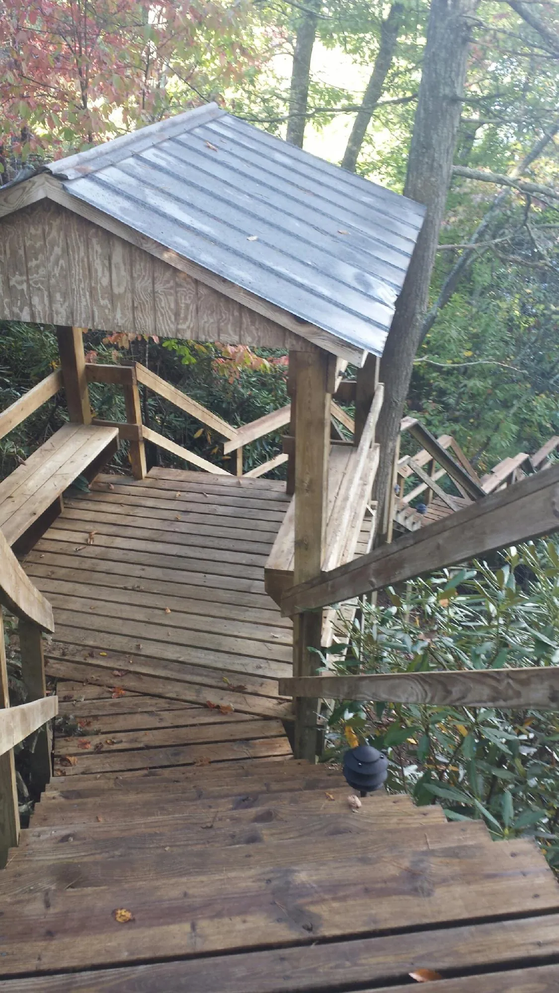 Metal roofed shelter over wooden steps on a wooded walkway — Skylight Repair & Installation work by our crew in High Ridge